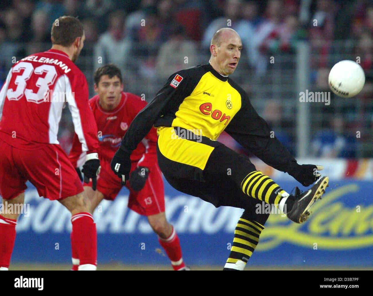 (dpa) - Dortmund's Czech forward Jan Koller (front R) kicks the ball while Cottbus players Ronny Thielemann (L) and Zsolt Loew from Hungary (back) look on, during the Bundesliga soccer match FC Energie Cottbus against Borussia Dortmund in Cottbus, Germany, 14 December 2002. Cottbus was defeated 0-4  Stock Photo