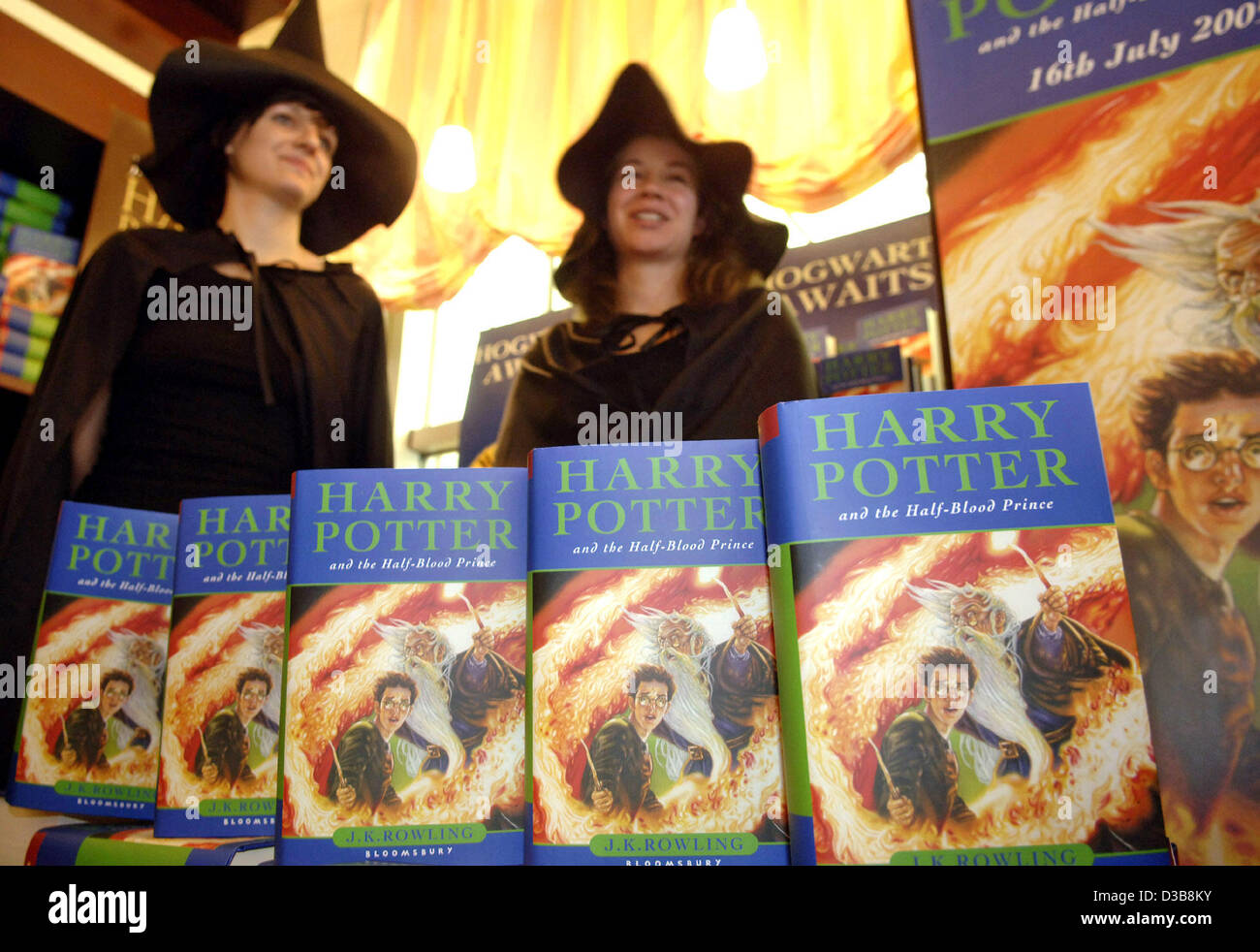 (dpa) - Two book sellers dressed in witch costumes stand behind a display of  Harry Potter books in Berlin, Saturday, 16 July 2005. Since the morning of Saturday 16 July 2005 the long awaited original version of the sixth volume 'Harry Potter and the Half-Blood Prince' by British author J.K. Rowling Stock Photo