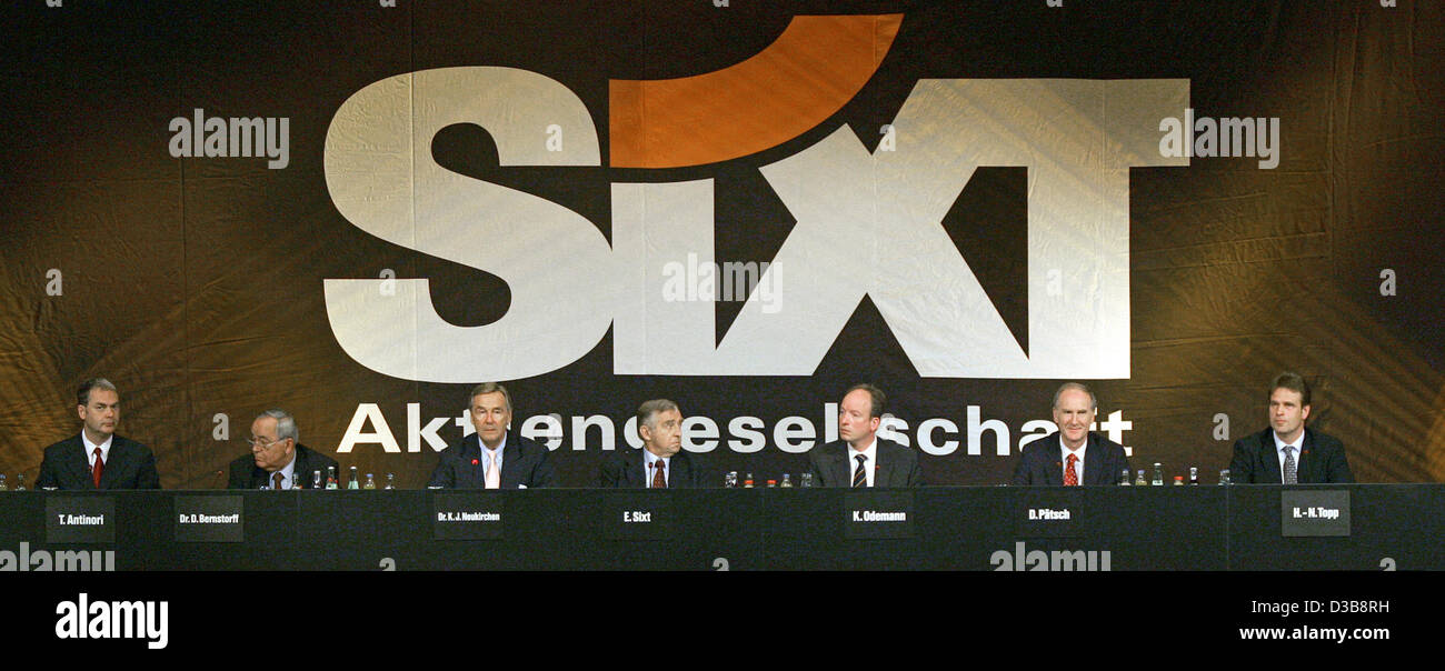 (dpa) - Members of the executive and advisory boards of the Sixt AG sit under an oversize logo of the group during the general meeting in Munich, Germany, Thursday 14 July 2005. Germany's biggest car rental goup is not willing to lay open the salaries of its executive and supervisory boards. The sha Stock Photo