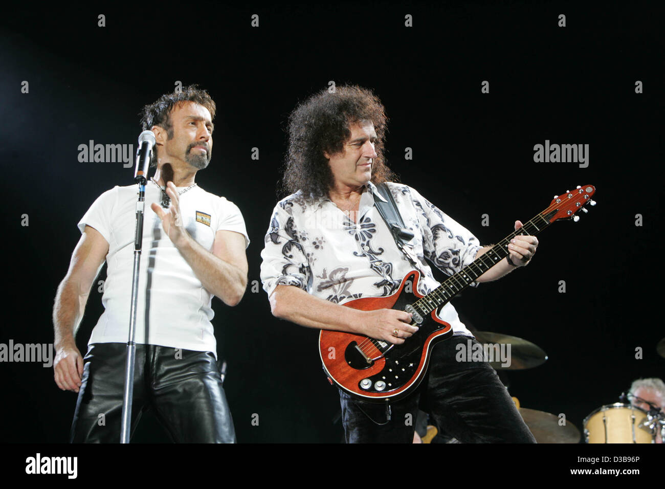 (dpa) - Brian May (R), member of the British pop band Queen, and singer Paul Rodgers perform at the RheinEnergieStadion in Cologne, Germany, 06 July 2005. Queen performed an additional concert in front of 30,000 concert goers. Stock Photo