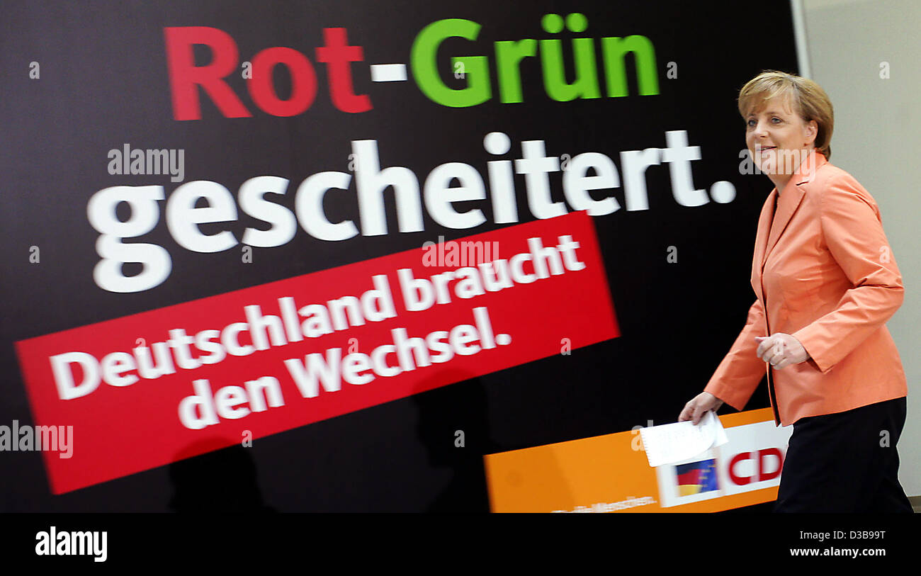 (dpa) - Chairwoman of the CDU Angela Merkel passes an election poster of the CDU in Berlin, Germany, 05 July 2005. Merkel commented on the recently released election manifesto of the SPD for the expected general election in September. Stock Photo