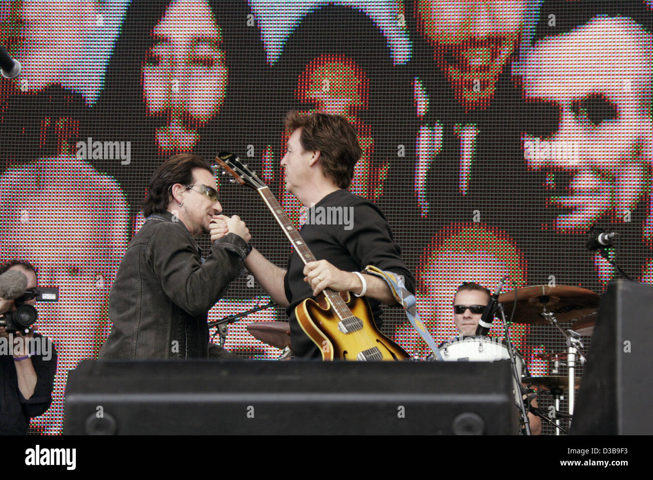 (dpa) - Bono (L) of the British rock band U2 and Paul McCartney perform during the Live 8 Concert in Hyde Park in London, England, 2 July 2005. The concert, held simultaneously in many cities around the world including Paris, Berlin, Philadelphia and Rome, aims to call attention to world poverty in  Stock Photo