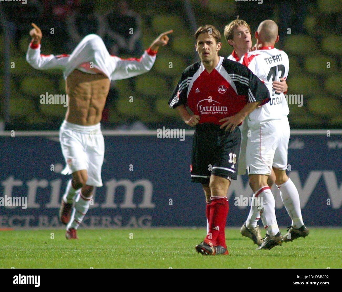 (dpa) - Stuttgart's goal scorer Kevin Kuranyi pulls the tricot over his head while Nuremberg's Tommy Larsen (2nd from L) looks disappointed during the Bundesliga soccer match VfB Stuttgart against First FC Nuernberg in Nuremberg, Germany, 20 October 2002. On the right Stuttgart's players Aliaksandr  Stock Photo