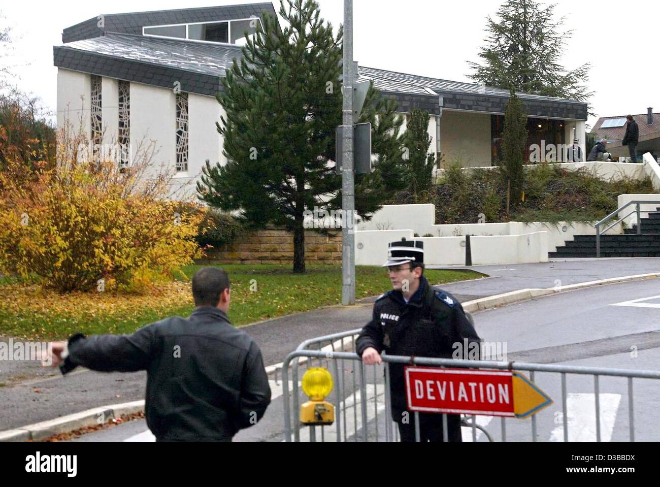 (dpa) A police officer stands next to a route diversion sign as he