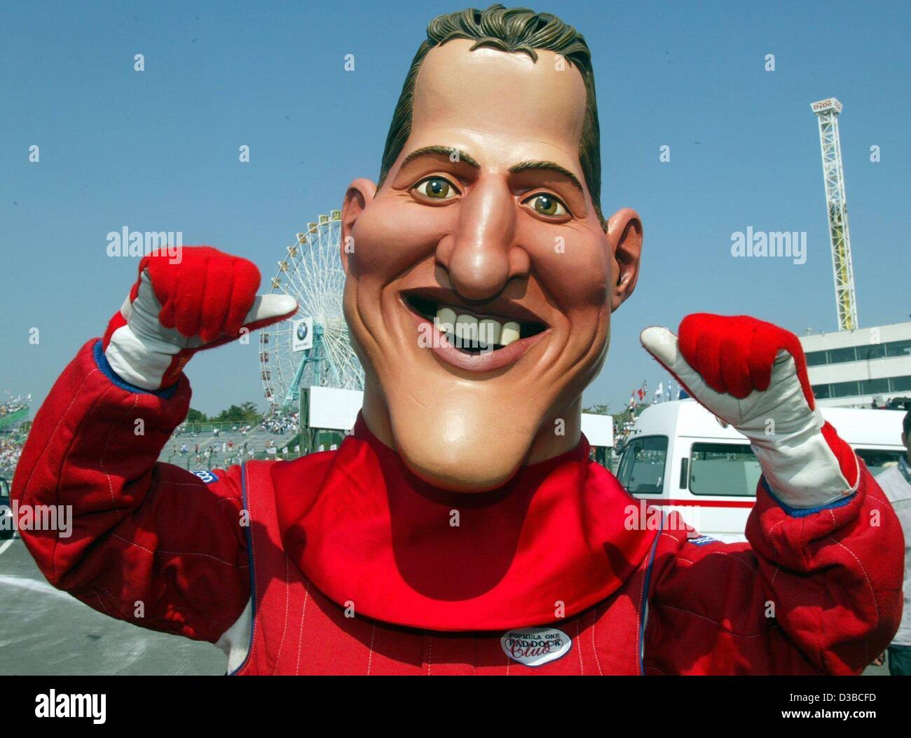 dpa) - A man wears a huge mask with the face of German formula one champion  Michael Schumacher at the racing court in Suzuka, Japan, 13 October 2002.  Michael Schumacher wins the