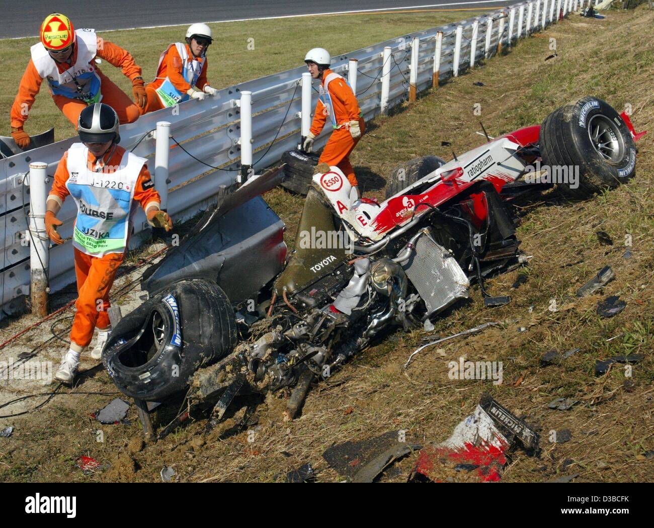 (dpa) Helpers rush to the wreck of the crashed formula one car of