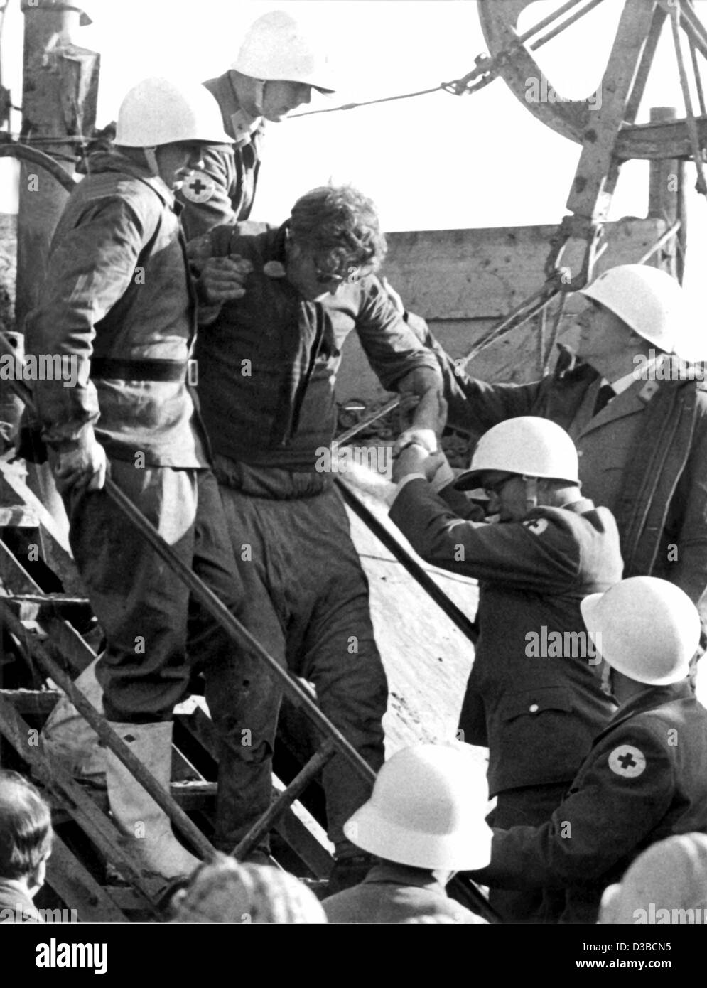 (dpa files) - Miner Fritz Baer is the second man to be rescued from the ore mine 'Mathilde' in Lengede, West Germany, 7 November 1963. 500 miners eye-witness the rescue operations at the platform of the drilling derricks. On 24 October a burst dam had flooded the mine and trapped 129 miners; 29 men  Stock Photo