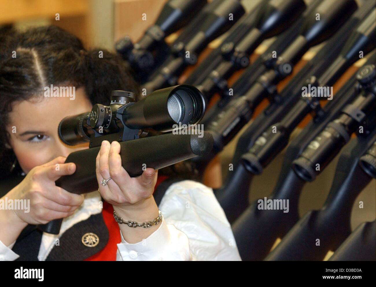 (dpa) - Ilonna spies through the telescopic sight of a hunting rifle at the hunting trade fair in Dortmund, Germany, 27 January 2003. 560 exhibitors from 26 countries present their products on Europe's largest hunting and fishing fair 'Hunt & Dog 2003'. Around 7000 visitors are expected to attend un Stock Photo