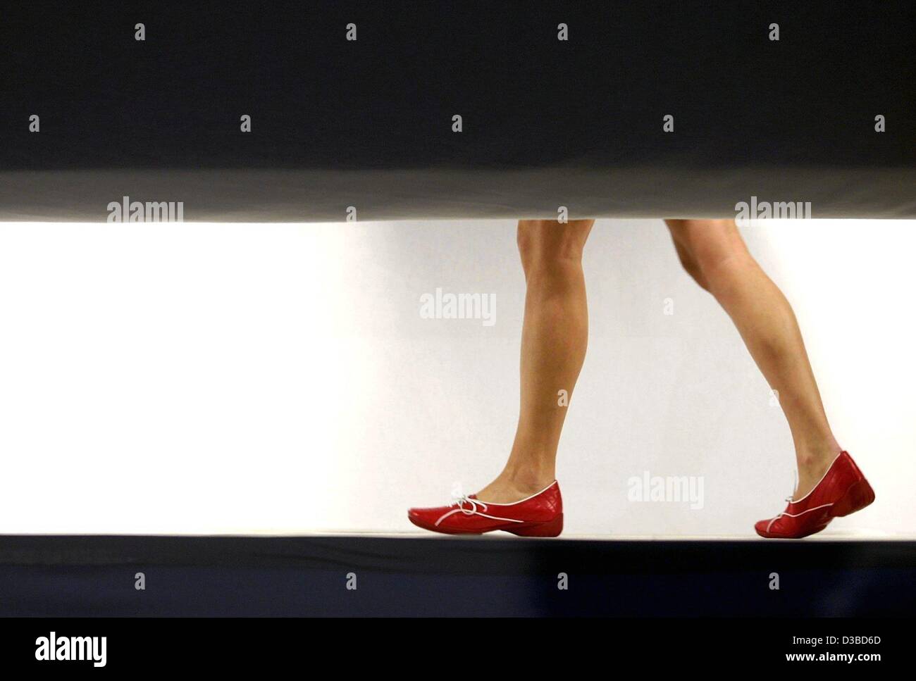 (dpa) - A model presents a light red pair of shoes of the spring/summer collection 2003 by Goertz and Belmondo, Hamburg, Germany, 29 January 2003. Among others, court shoes and ankle boots are the eye catchers of the latest ladies' collection. Stock Photo