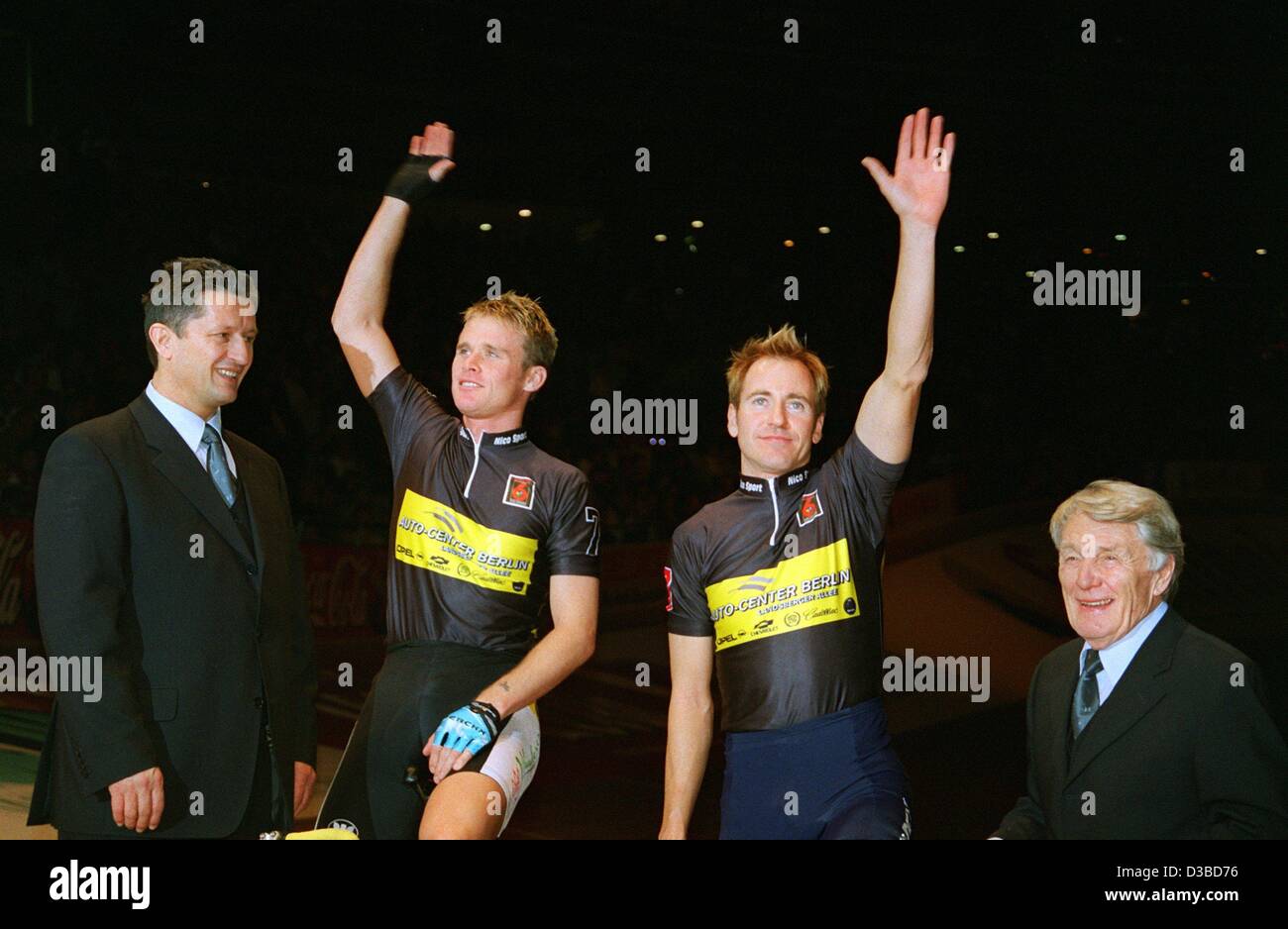 (dpa) -  Australian cyclist Scott McGrory (2nd from R) and his Belgian partner Matthew Gilmore (2nd from L), the winners of the 39th Six Days of Munich race, wave their hands and are introduced to the spectators of the event by the sports directors Otto Ziege (R) and Dieter Stein (L) at the Six Days Stock Photo