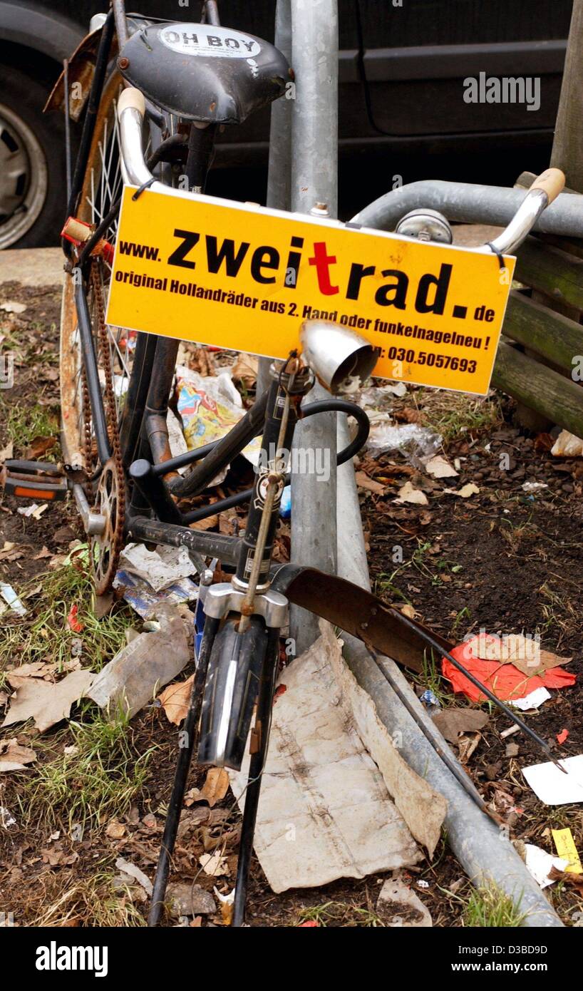 (dpa) - A yellow sign posted on a vandalized bicycle advertises a Berlin bike shop in Berlin, 21 January 2003.  The sign reads 'original Hollandraeder aus 2. Hand oder funkelnagelneu' (original Dutch bicycles, used or gleaming brand-new) and provides the shop's e-mail address and telephone number. Stock Photo