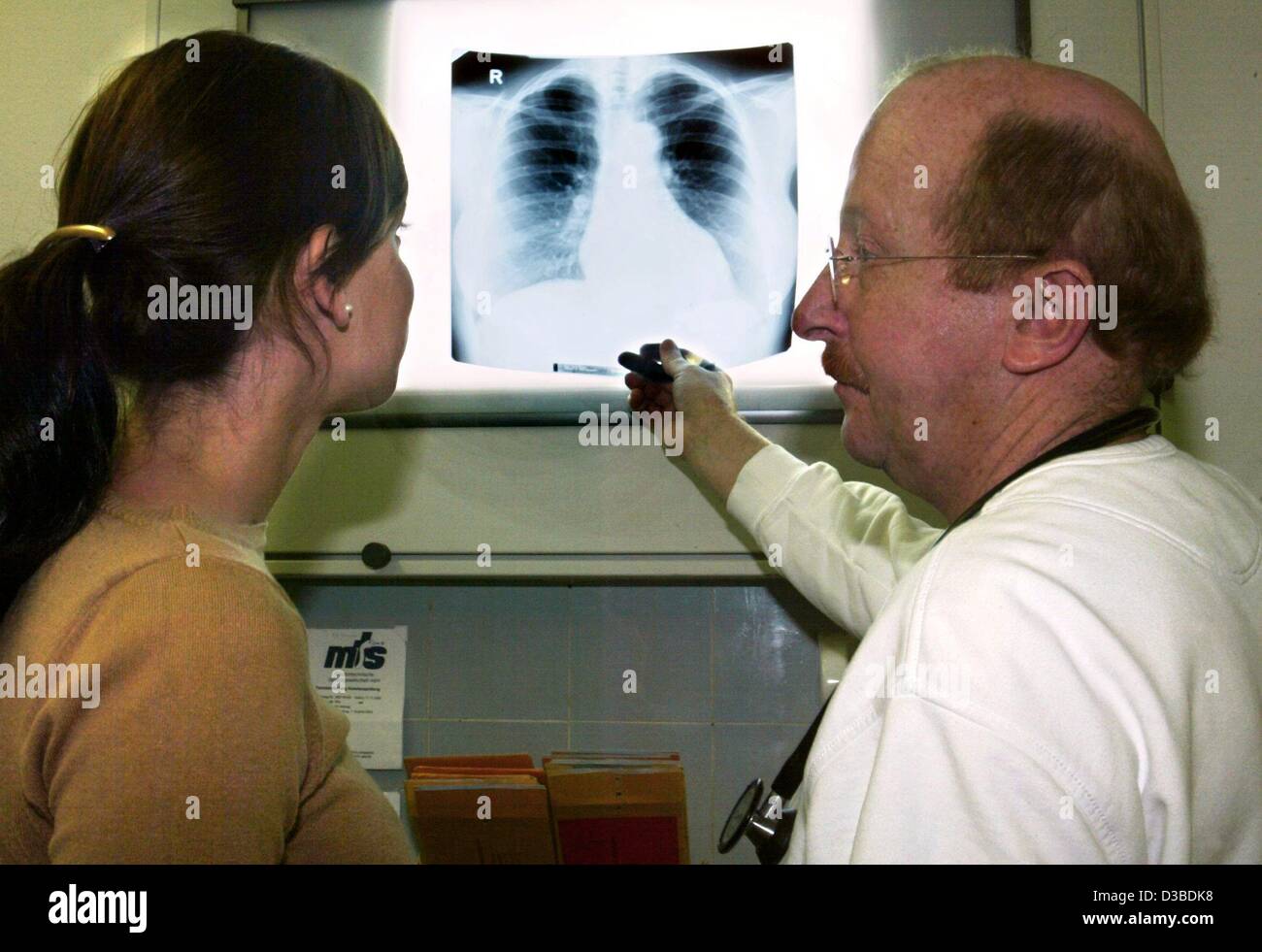 (dpa) - A doctor talks to a patient about a radiogram of the ribcage at a doctor's practice in Duesseldorf, Germany, 23 January 2003. Stock Photo