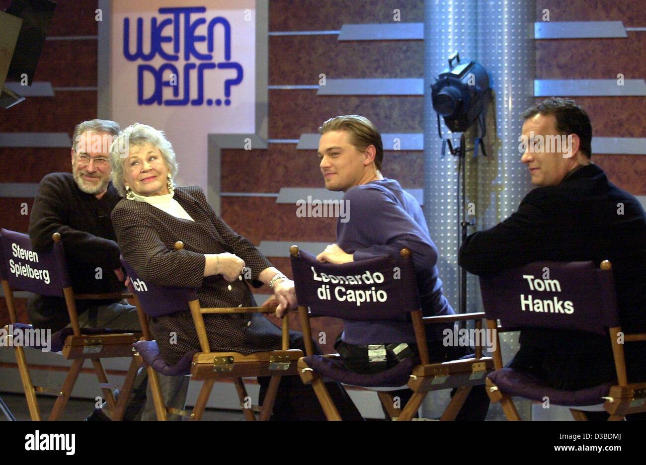 (dpa) - US film director Steven Spielberg (L) and US actors Leonardo DiCaprio (2nd from R) and Tom Hanks (R) pose with Erika, a lady from the audience, in director chairs during the German TV show 'Wetten dass...?' (bet that...?), in Boeblingen, Germany, 25 January 2003. The Hollywood stars promoted Stock Photo