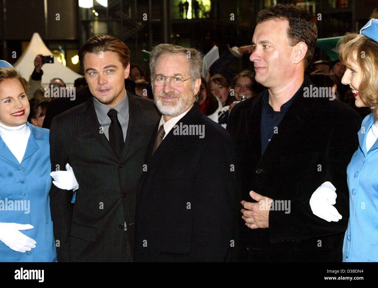 (dpa) - US actors Leonardo DiCaprio (L) and Tom Hanks (R) pose with their director Steven Spielberg (C) and hostesses ahead of the German premiere of their new film 'Catch Me If You Can' in Berlin, 26 January 2003. The film, based on a true story, is about a successful con artist (DiCaprio) who mana Stock Photo