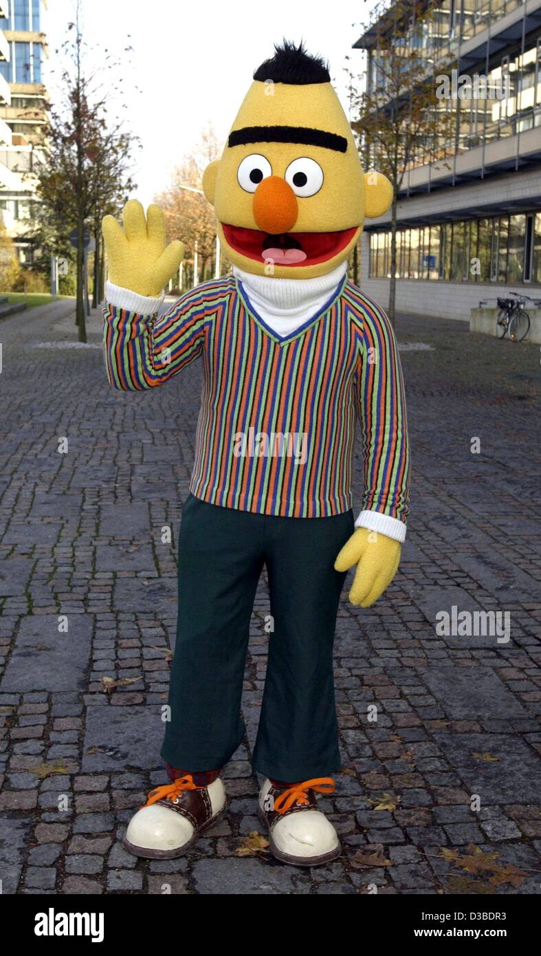 (dpa) - Bert from the Sesame Street show stands in an alley way and waves his hand on the premises of the NDR (German radio and television station) in Hamburg, 27 November 2002. On the occasion of the 30th Birthday of Sesame Street, Ernie and Bert visit celebrities on a benefit tour through Germany. Stock Photo
