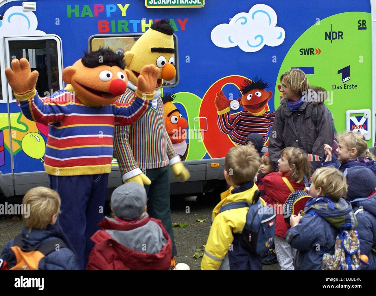 (dpa) - Ernie (L) and Bert meet and greet children on the street in front of their Sesame Street tour bus in Berlin, 19 November 2002. The first season of the German edition was broadcast in January 1973. On the occasion of the 30th Birthday of Sesame Street, Ernie and Bert visit celebrities on a be Stock Photo