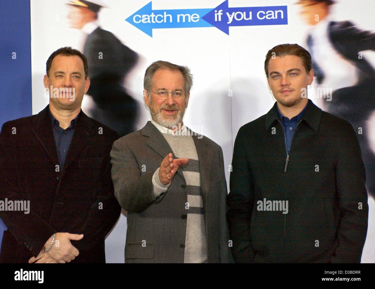 (dpa) - US actors Tom Hanks (L) and Leonardo DiCaprio (R) as well as US film director Steven Spielberg pose in front of a movie poster ahead of the German premiere of their new film 'Catch Me If You Can' in Berlin, 26 January 2003. The film, based on a true story, is about a successful con artist (D Stock Photo