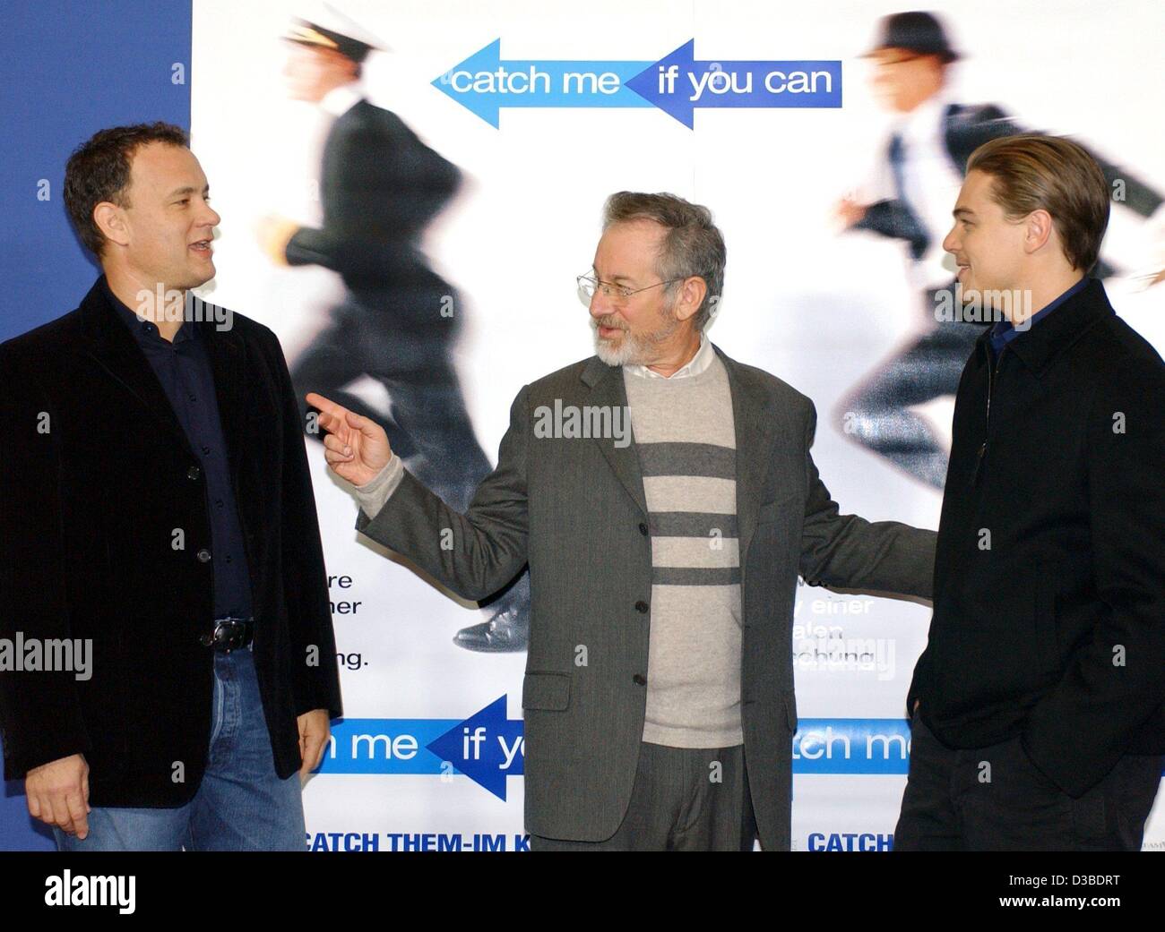 (dpa) - US actors Tom Hanks (L) and Leonardo DiCaprio (R) as well as US film director Steven Spielberg pose in front of a movie poster ahead of the German premiere of their new film 'Catch Me If You Can' in Berlin, 26 January 2003. The film, based on a true story, is about a successful con artist (D Stock Photo