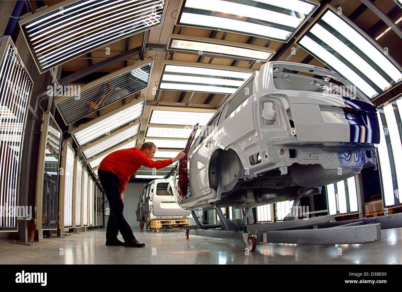 (dpa) - Holger Felgner checks car bodies in a tunnel of the new FlatScan system, developed to quickly see defects in car parts, at the company uwe braun in Lenzen, Germany, 16 January 2003. The company develops and produces the FlatScan systems to check defects in the paint and smallest damages in c Stock Photo