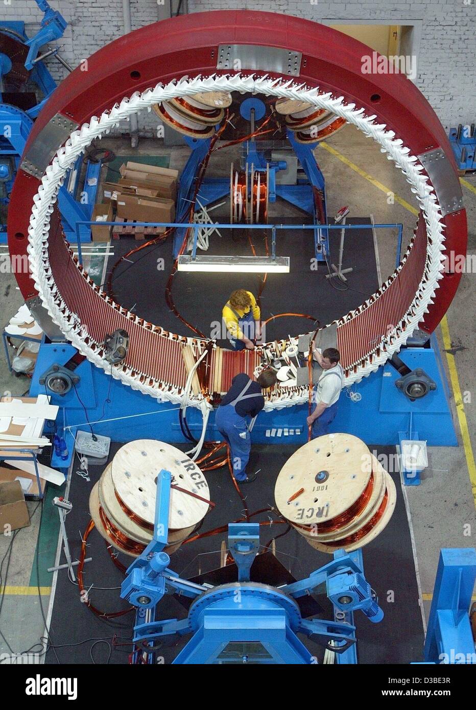 (dpa) - Enercon employees are working on the stator of a wind generator, Magdeburg, 22 January 2003. Enercon is considered the market leader in the production of wind power plants. Stock Photo