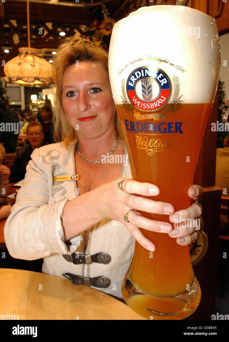 dpa) - A woman with both hands holds up a three-litre-glass of Bavarian  'white beer' (Weissbier) at the Green Week ('Gruene Woche') trade fair in  Berlin, 20 January 2003. The Green Week