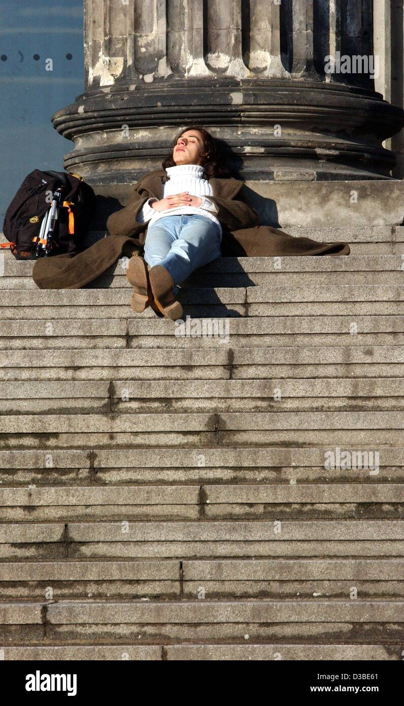 (dpa) - A young woman savors basking in the sun on the steps of the Altes Musuem (old museum) in Berlin, 20 January 2003.  With temperatures approaching 8 degrees Celsius (46 degrees Fahrenheit) and sparkling sunshine, some are lured outdoors to enjoy Berlin's winter weather. Stock Photo