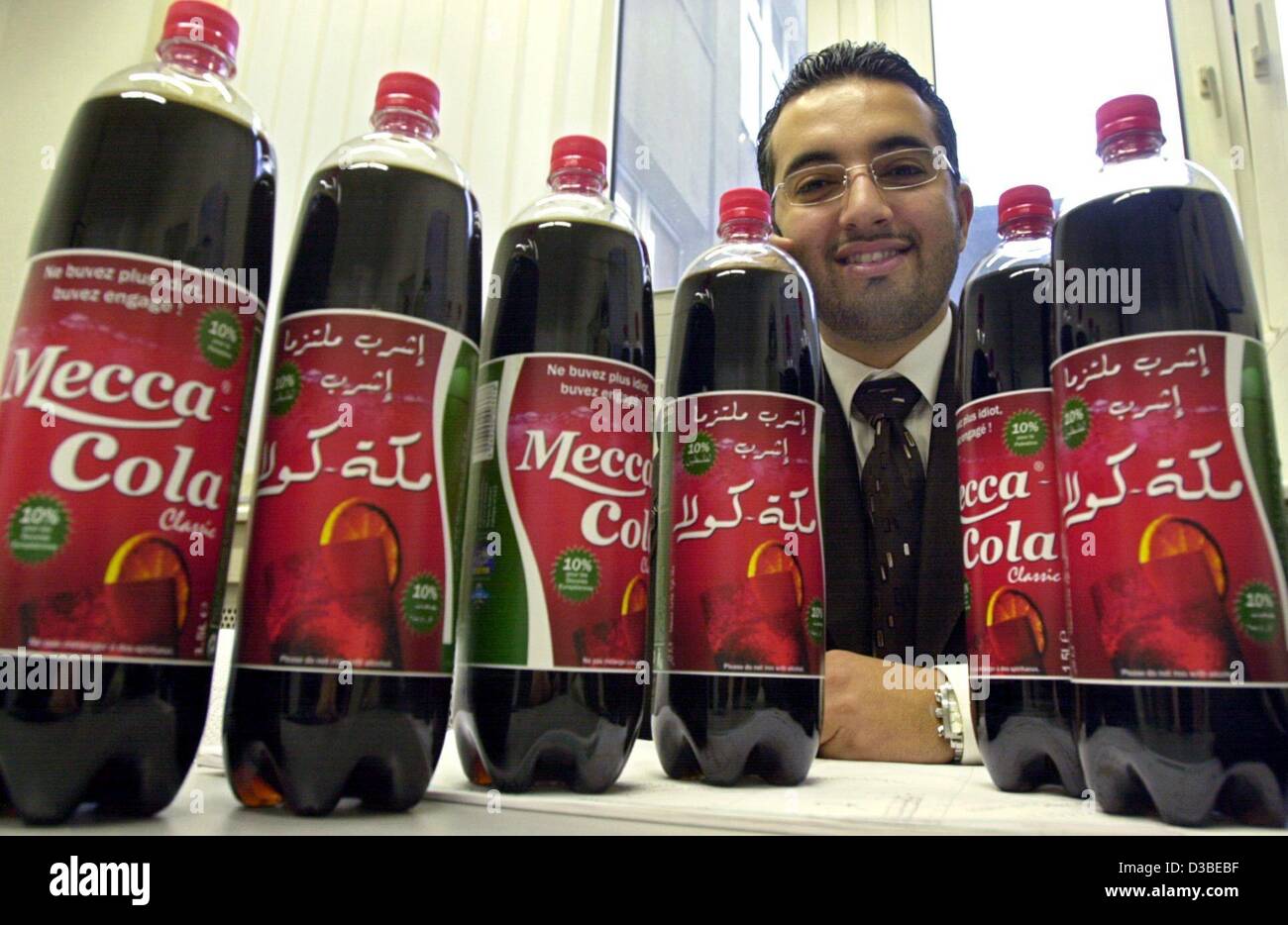 (dpa) - Mahmoud Hinnaui presents some bottles of 'Mecca Cola' in Hamburg, 15 January 2003. Mecca Cola is the Islamic version of Coca Cola. Since beginning of December 2002 Hinnaui started to sell the softdrink in his adopted country Germany, with growing success. The 28-year-old Syrian lives in Germ Stock Photo