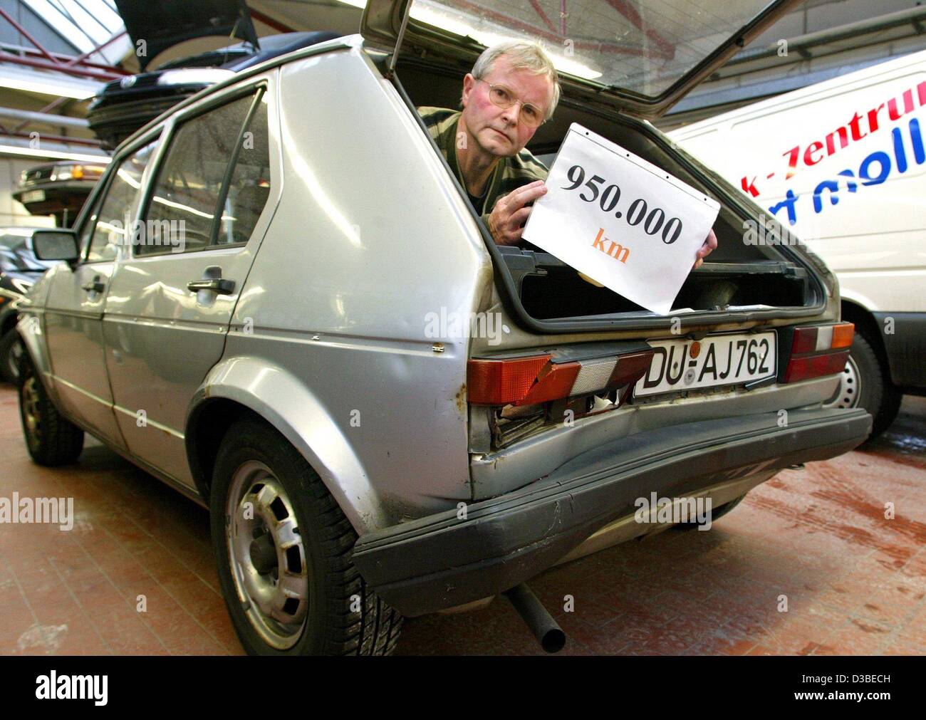 (dpa) - Hans-Dieter Gehlen from Duisburg looks out of his car holding a sign which says '950,000km' in Duesseldorf, Germany, 15 January 2003. Exactly one year ago, newspapers reported that Gehlen's VW Golf (70 hp, built in 1983) had rolled 900,000km with its first engine. Since then, it is heading f Stock Photo