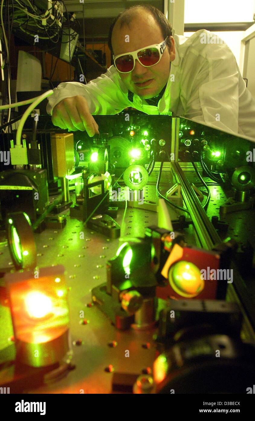 (dpa) - A member of the 'Gesellschaft für Schwerionenforschung GSI' (heavy ion research centre) works at a pre-amplifier of a laser in a laboratory in Darmstadt, Germany, 2 December 2002. He wears protective glasses to prevent eye injuries. GSI want to create the strongest laser in Germany in a few  Stock Photo