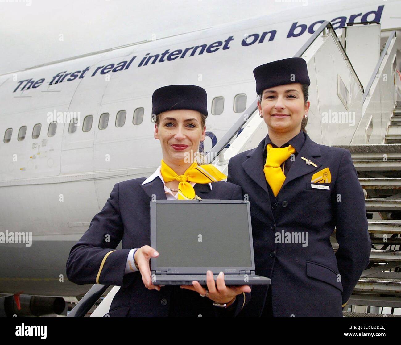 (dpa) - Two Lufthansa stewardesses are posing with a laptop on the steps to a Boeing 747-400 labelled with the slogan 'The first real internet on board', Frankfurt, 15 January 2003. Lufthansa is the first airline to be testing a fast access to the internet for passengers. This is offered on schedule Stock Photo