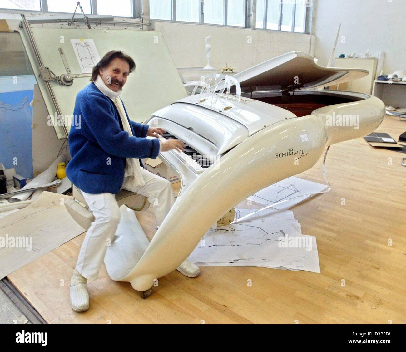 (dpa) - Industrial designer Luigi Colani is posing with a grand piano in his workshop in Karlsruhe, Germany, 13 January 2003. Musicians like Lenny Kravitz and Prince own such an elegantly streamlined Colani concert grand. The Berlin born has been fighting against straight and angular forms for decad Stock Photo