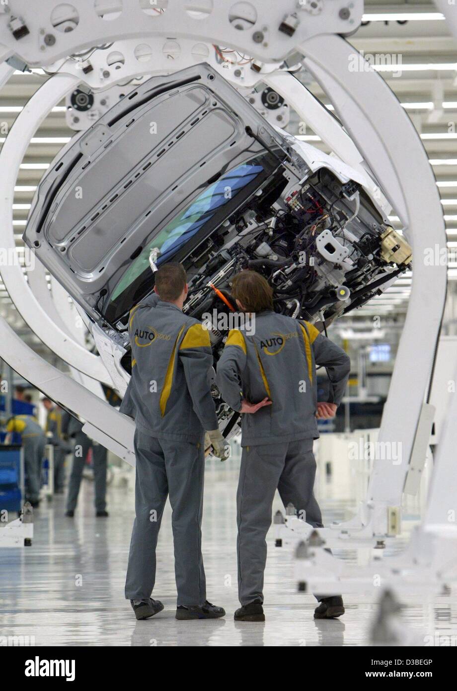 (dpa) - Two workers assemble parts of the new VW Touran on an assembly line in Wolfsburg, Germany, 13 January 2003. The Touran is a van based on the model of the VW Golf. The workers were employed in the scope of the project '5000 mal 5000' (5,000 times 5,000), which aims to create 5,000 new jobs. T Stock Photo