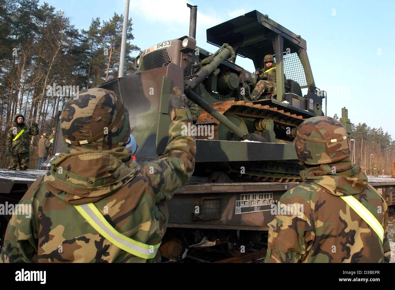 (dpa) - US soldiers direct a caterpillar on a train in Vilseck, Germany, 9 January 2003. The US army has started to load military equipment in Germany for a possible war against Iraq. 500 of the 800 US soldiers of the 5th US Corps will be relocated to the Middle East. Stock Photo