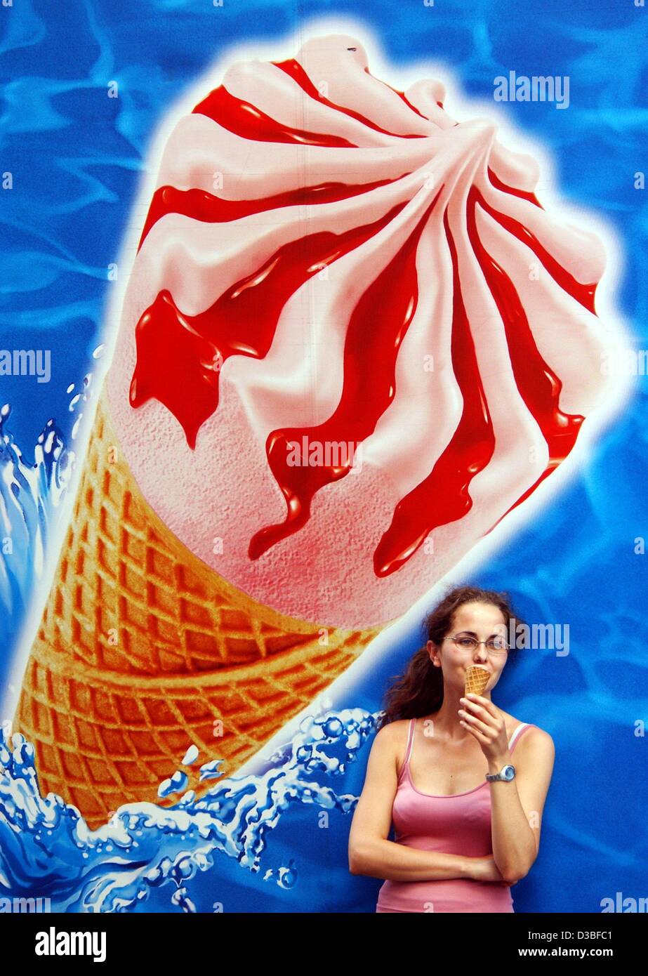 (dpa) - A young woman savours her ice-cream wafer in front of a huge ice advertisement on a lorry, in Frankfurt, Germany, 23 June 2003.  keywords: Lifestyle-Leisure, LIF, Gastronomy, ice cream, huge, cornetto, eiswaffel, ice-cream wafer, GERMANY:DEU, Feature, single Stock Photo