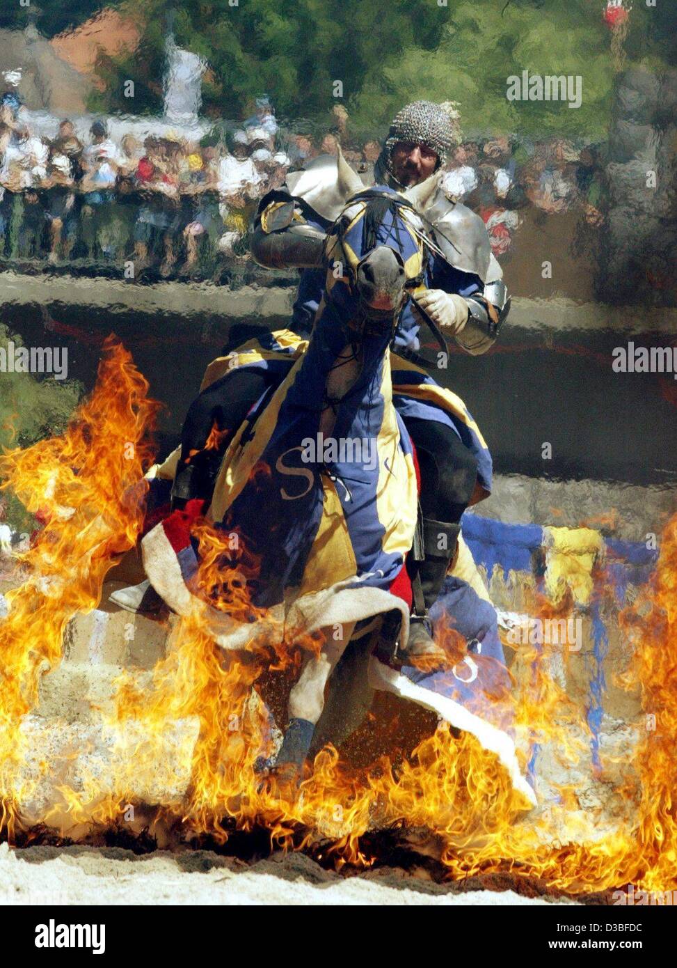 (dpa) - An armoured knight on his horse races through a wall of fire during the mediaeval  'Maximilian Ritterspiele' (Maximilian knight joust) in Horb, Germany, 21 June 2003. The joust dates back to the visit of the German emperor in the town of Horb in 1498. The festival spectacle reminds of this o Stock Photo