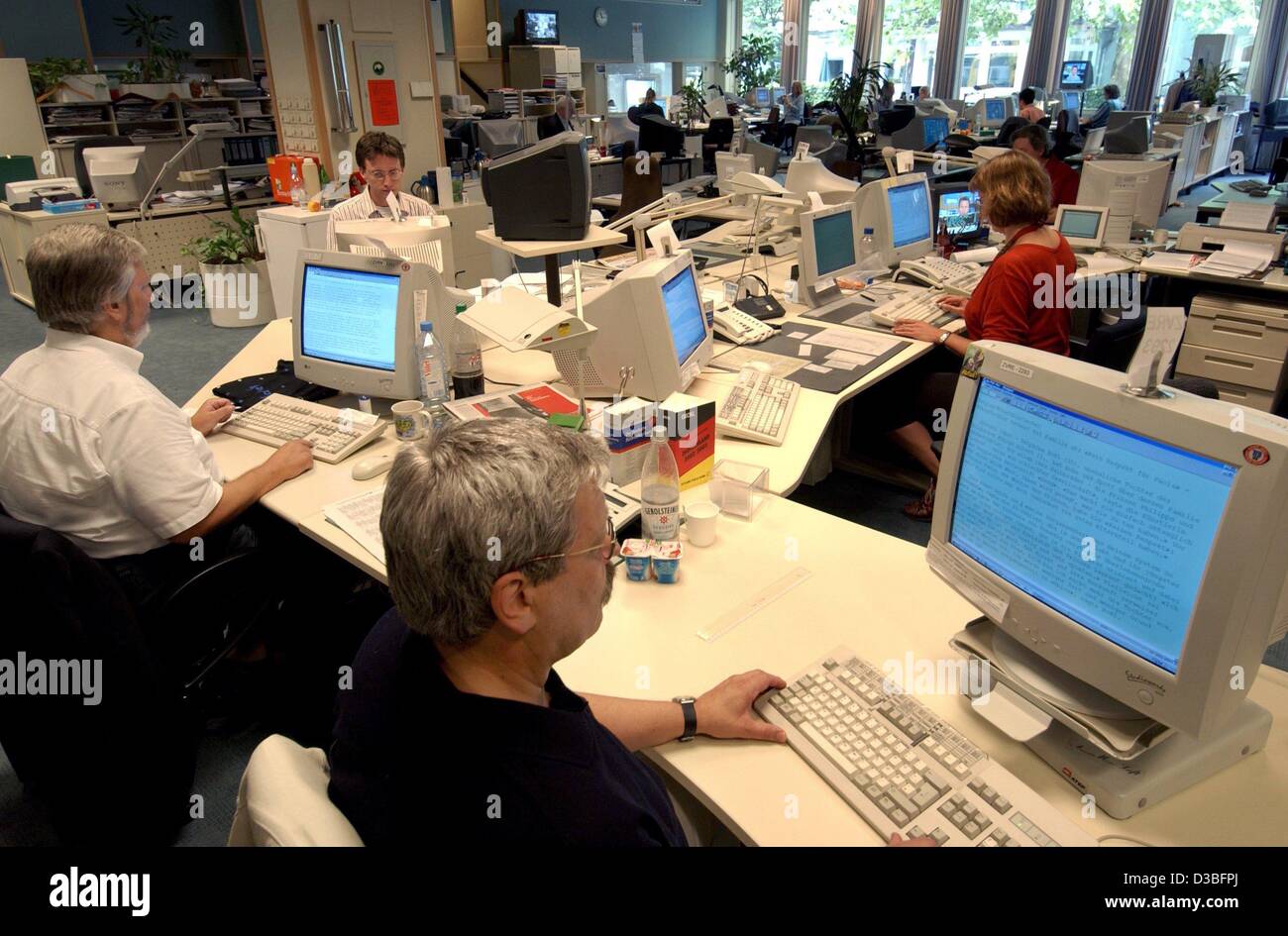 (dpa) - Employees in the editorial department sit at their desks in front of computers at the headquarters of the 'Deutsche Presse-Agentur GmbH' (German press agency) in Hamburg, Germany, 26 June 2003. The agency announced during a press conference on 26 June 2003 a decrease in turnover by 0,4 perce Stock Photo