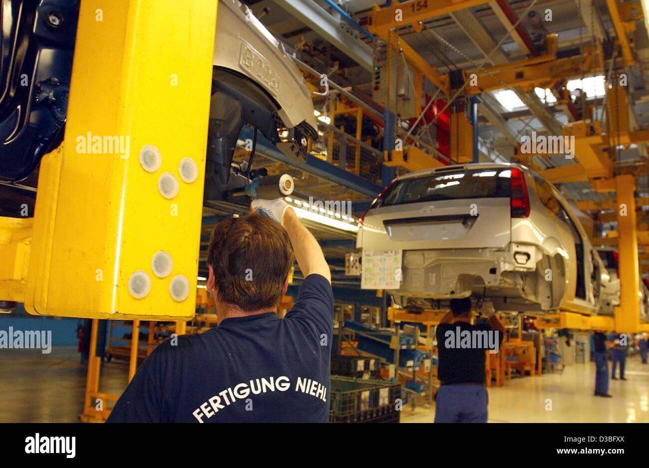 (dpa) - Employees of Ford car manufacturer work on the production of a Ford 'Fiesta' in the Ford production plant in Cologne, Germany 23 June 2003. The factory employs 20,800 workers from 57 countries. Ford has based its German heaquarters in Cologne since 1931 but operates further manufacturing pla Stock Photo