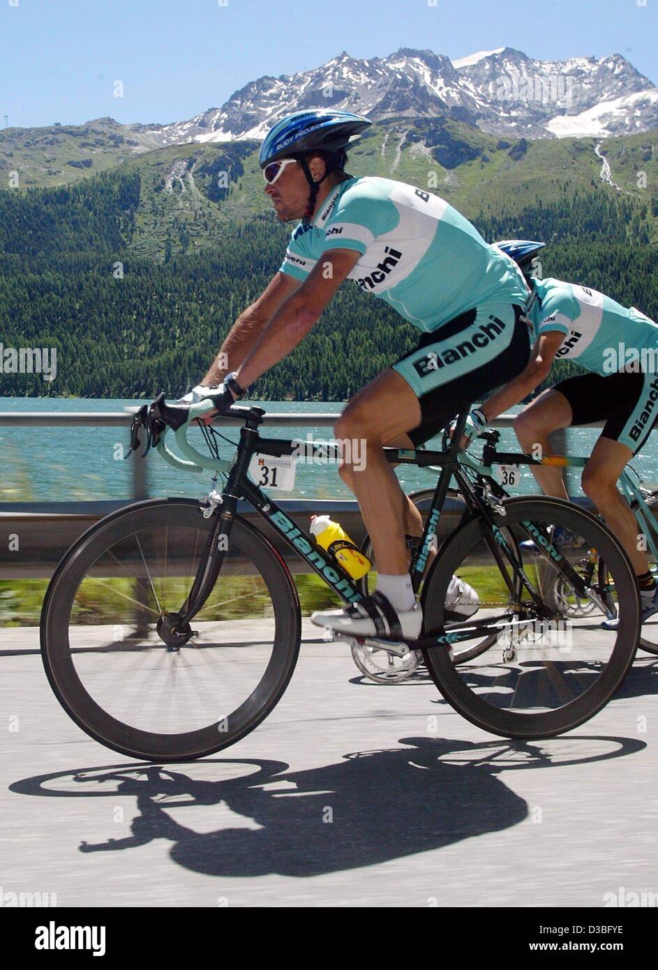 (dpa) - German Olympic winner Jan Ullrich (Team Bianchi) rides along a country road past a scenery with mountains and a lake in the 6th leg during the Tour de Suisse in Silvaplana, Switzerland, 22 June 2003. Ullrich wins second place in the 6th leg which covers a distance of 134 kilometres around Si Stock Photo