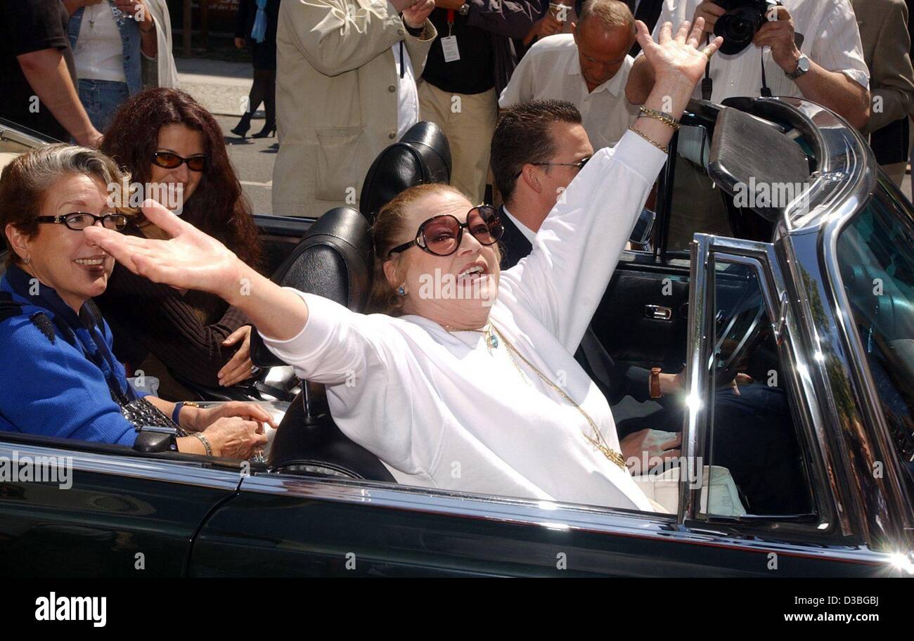 (dpa) -  Swedish actress Anita Ekberg cheers to her fans while she drive in a convertable on her way to the inauguration of a water fountain in Berlin, 20 June 2003. Ekberg rose to fame for her role in Federico Fellini's film 'La dolce vita' (1959) in which she took her famous nightly bath in the Tr Stock Photo