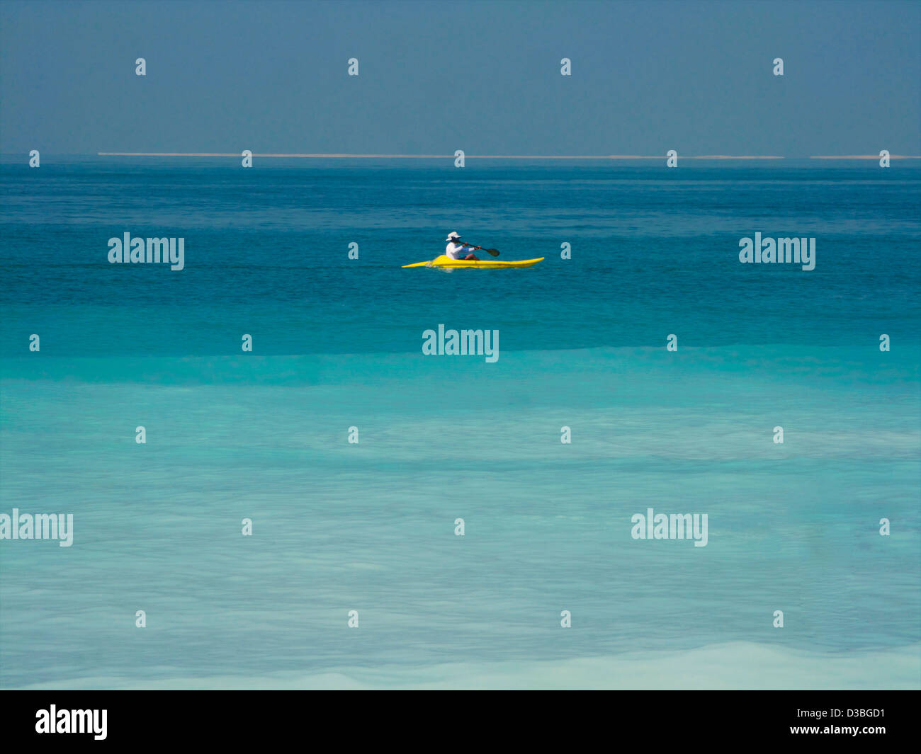 A lifeguard patrols the waters around the Burj al Arab hotel in a canoe through crystal blue waters Stock Photo