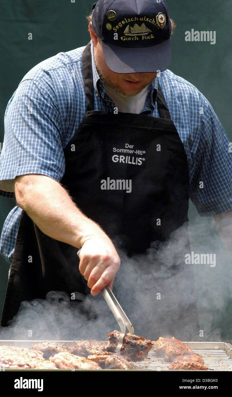 dpa) - A contestant swiftly turns over the meat on his grill during the  German barbecue championships in Bad Lippsringe, Germany, 31 May 2003. Both  amateurs and professionals compete in Bad Lippsringe.