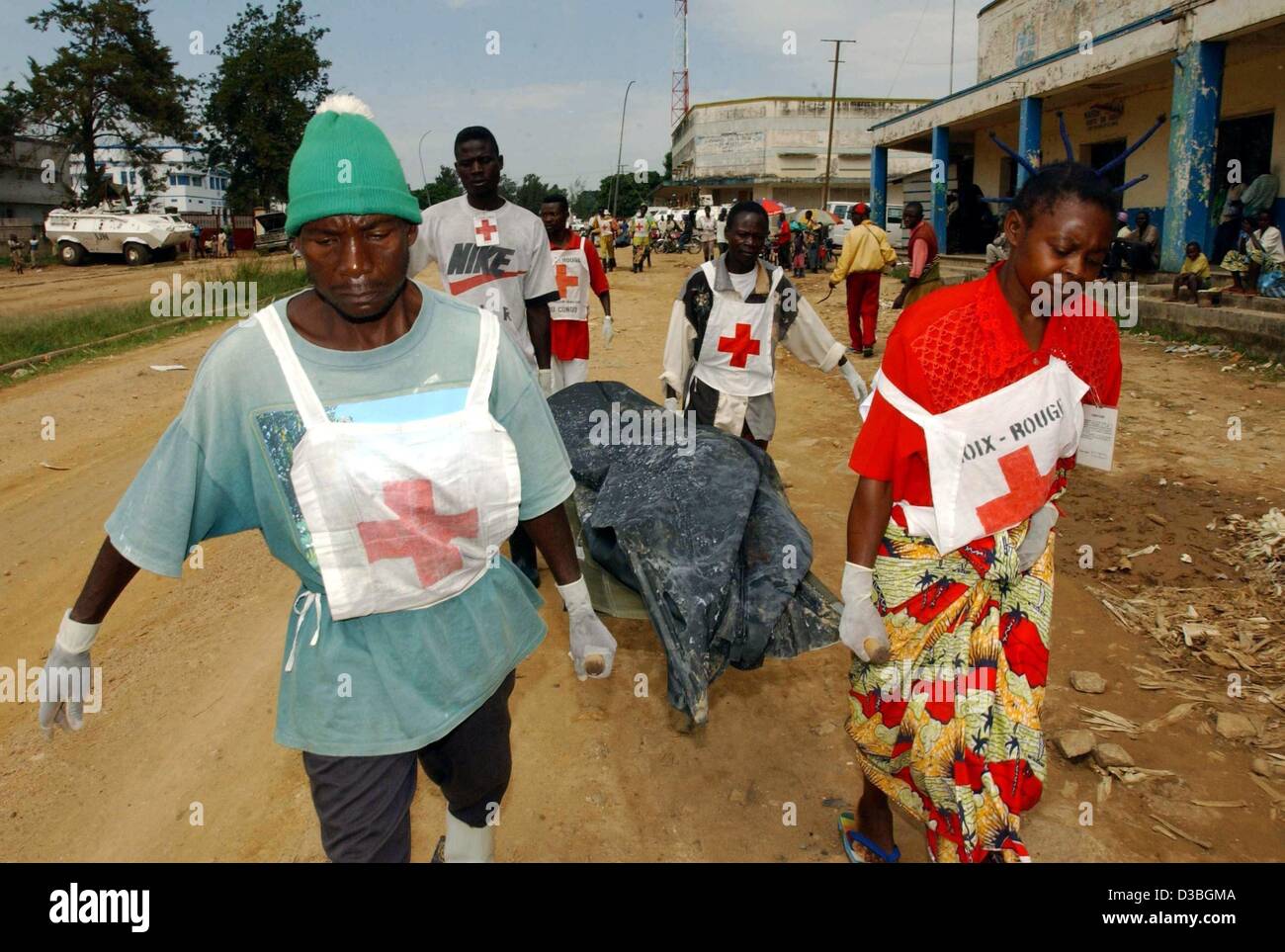 (dpa) - Members of the Red Cross rush along a street and carry the covered up body of a dead militiaman on a stretcher in Bunia, Democratic Republic of Congo, 17 June 2003. The militiaman belonged to the Hema and was a member of the Union of Congolese Patriots (UPC). Two militiamen were shot by Fren Stock Photo