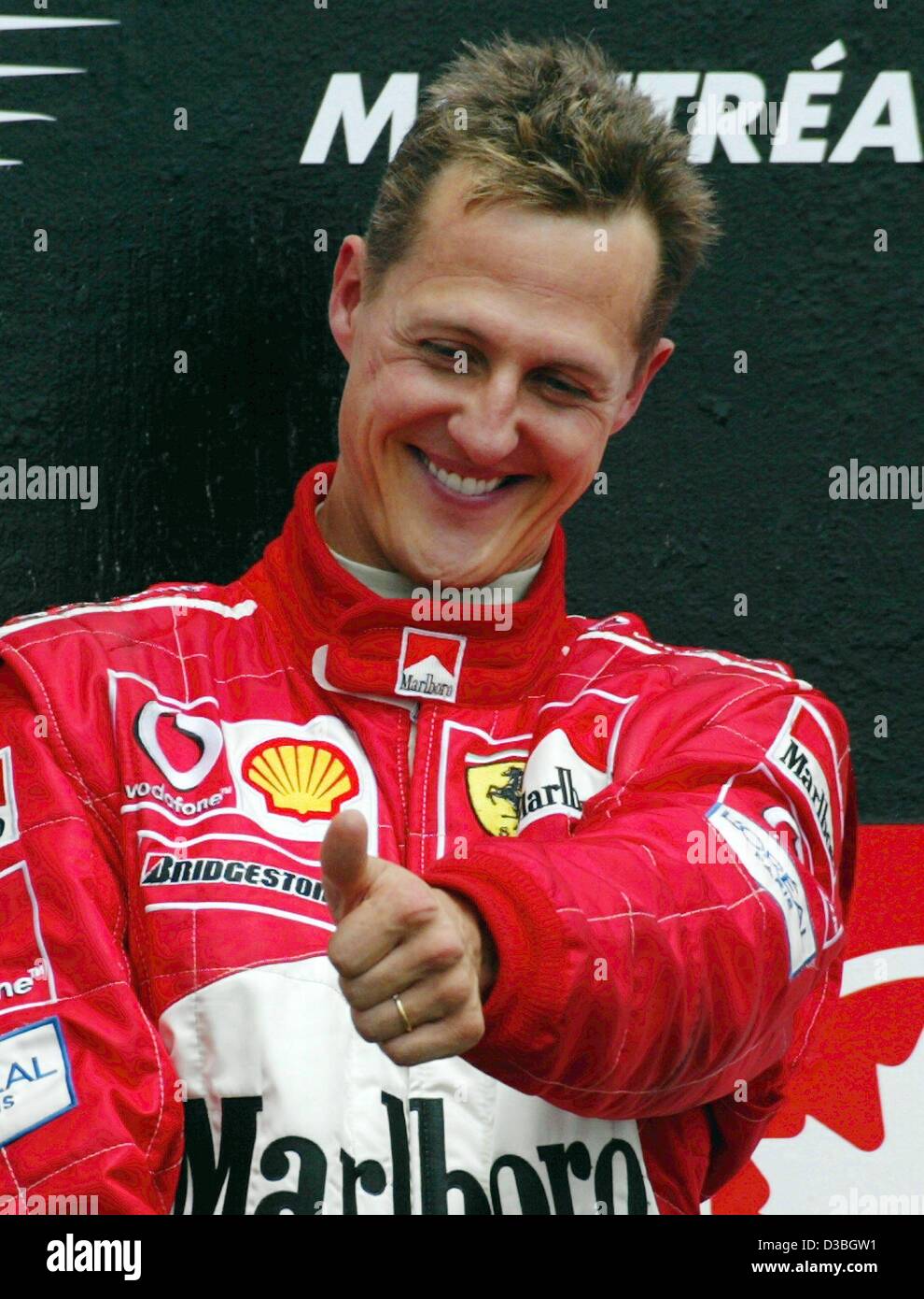 (dpa) - German formula one world champion Michael Schumacher (Ferrari) gestures a 'thumbs up'  during the awards ceremony on the Circuit Gilles Villeneuve formula one racing track after winning the Canadian Grand Prix in Montreal, Canada, 15 June 2003.  Michael Schumacher wins the race and leads in  Stock Photo