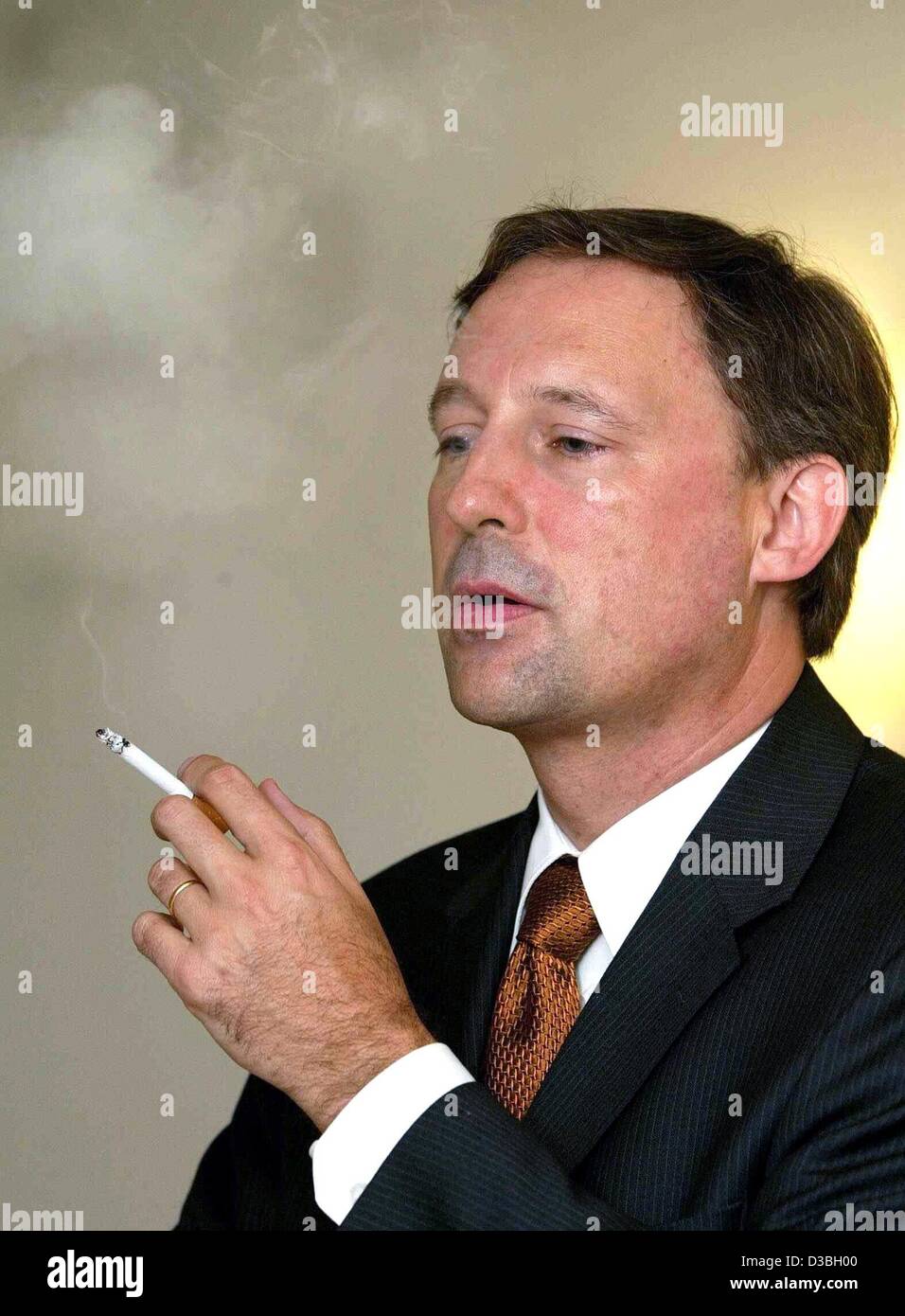 (dpa) - Detlef Zimmermann, Chairman of British American Tobacco (BAT), smokes a cigaret after the balance press conference in Hamburg, Germany, 5 June 2003. BAT sold 32,8 billion cigarets last year which reflects an increase in turnover by 2 percent. The company achieved the highest rate of growth i Stock Photo