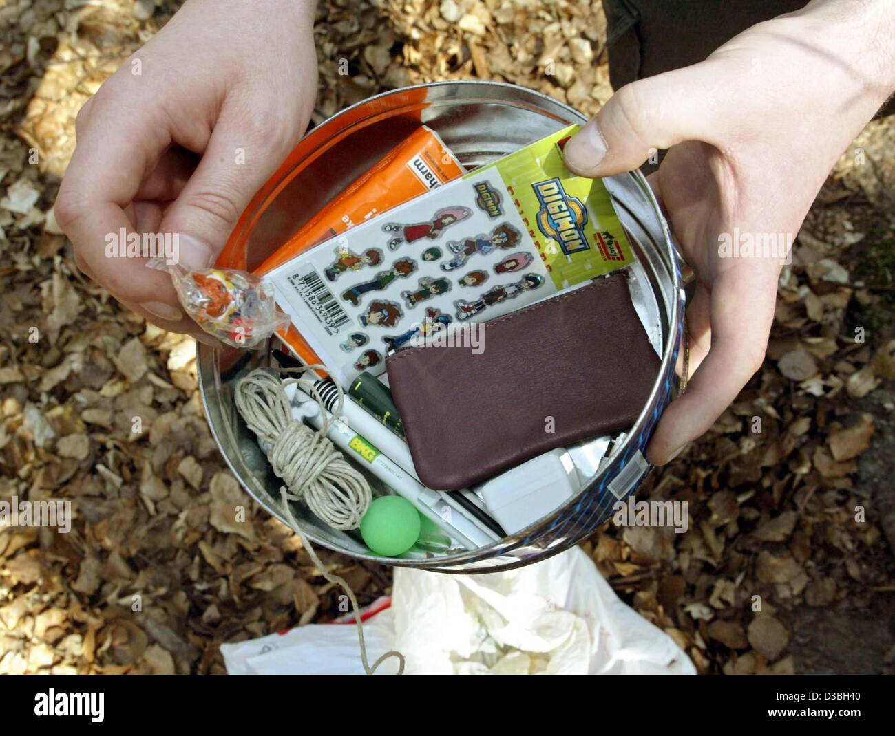 (dpa) - Geocoacher Axel Burgemeister shows the contents of a 'treasure' which had been published on the internet, and which he had found with a GPS system in a forest near Hagenbach, Germany, 14 April 2003. Geocoaching is a new hobby for old and young people: both kids and grownups enjoy going on tr Stock Photo