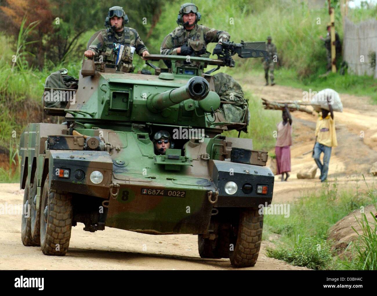 (dpa) - French soldiers in their tank pass Congolese people at a French army checkpoint in Bunia, Congo, 11 June 2003. The 1,400-strong international force, half of which will be French, will not be deployed outside Bunia - even though violence affects many other parts of resource-rich Ituri provinc Stock Photo