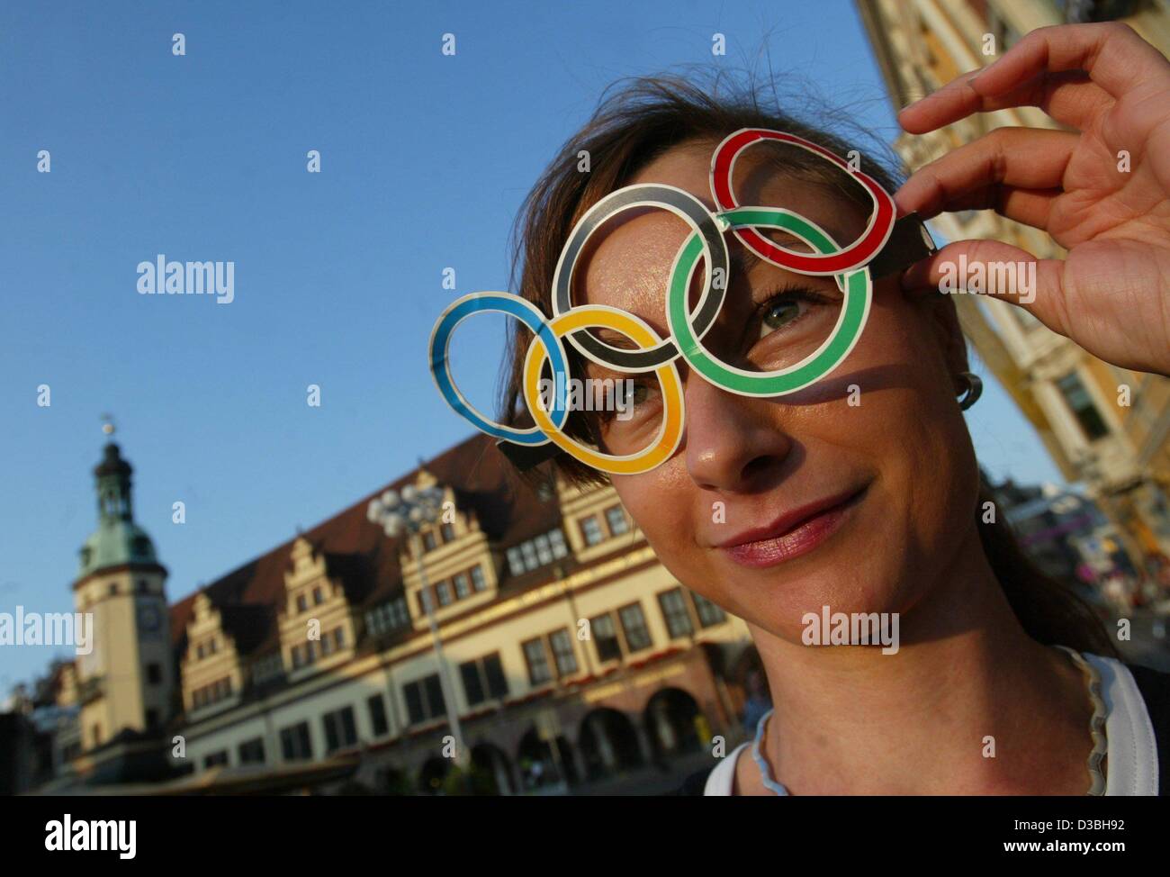 (dpa) - Daniela holds a cutout of the olympic symbole attached to her forehead while she stands in front of the old town hall in Leipzig, Germany, 2 June 2003. The German National Olympic Committee (NOC) selected Leipzig as their candidate for the Olympics 2012; the final decision of the IOC will be Stock Photo