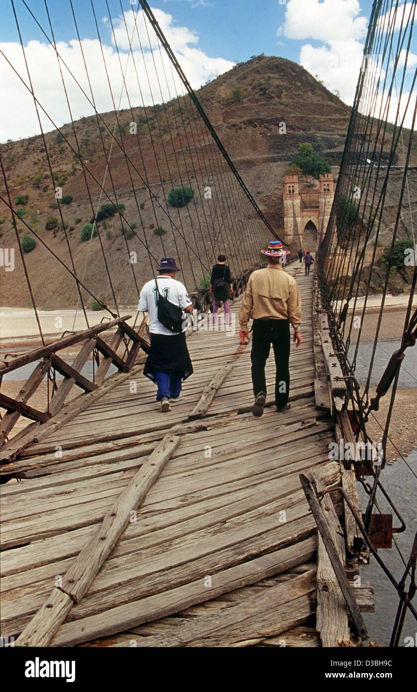 (dpa files) - People walk over the run-down suspension bridge Puente Sucre across the Rio Pilcomayo in the Departamento Chuquisaca, Bolivia, 2002. The bridge, built in 1890, is nowadays only used as a footbridge. Although Bolivia is rich in natural resources, it is one of the poorest countries of La Stock Photo