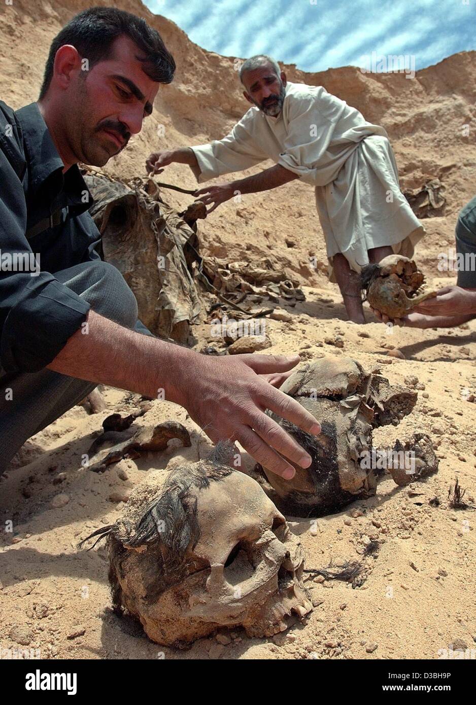 (dpa) - Some Iraqi men exhume the bones of dead Arabs in a mass grave in the desert 20 km south of the city of Karbala, Iraq, 2 May 2003. The victims were killed and buried during the uprising of the Shiites in 1991 by the regime of ousted Iraqi President Saddam Hussein. Stock Photo