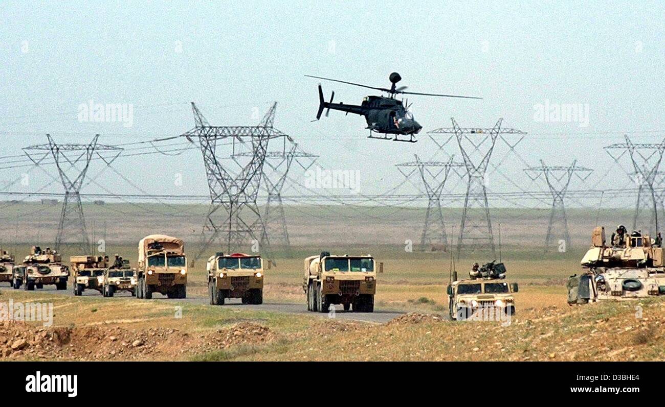 (dpa) - A US Army helicopter flies above the convoy of US military tanks and armoured vehicles which are moving to Northern Iraq, near Al-Sharkat, 25 April 2003. Stock Photo